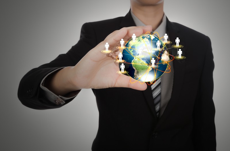 Business man holding the small world in his hands against white background (Elements of this image furnished by NASA)